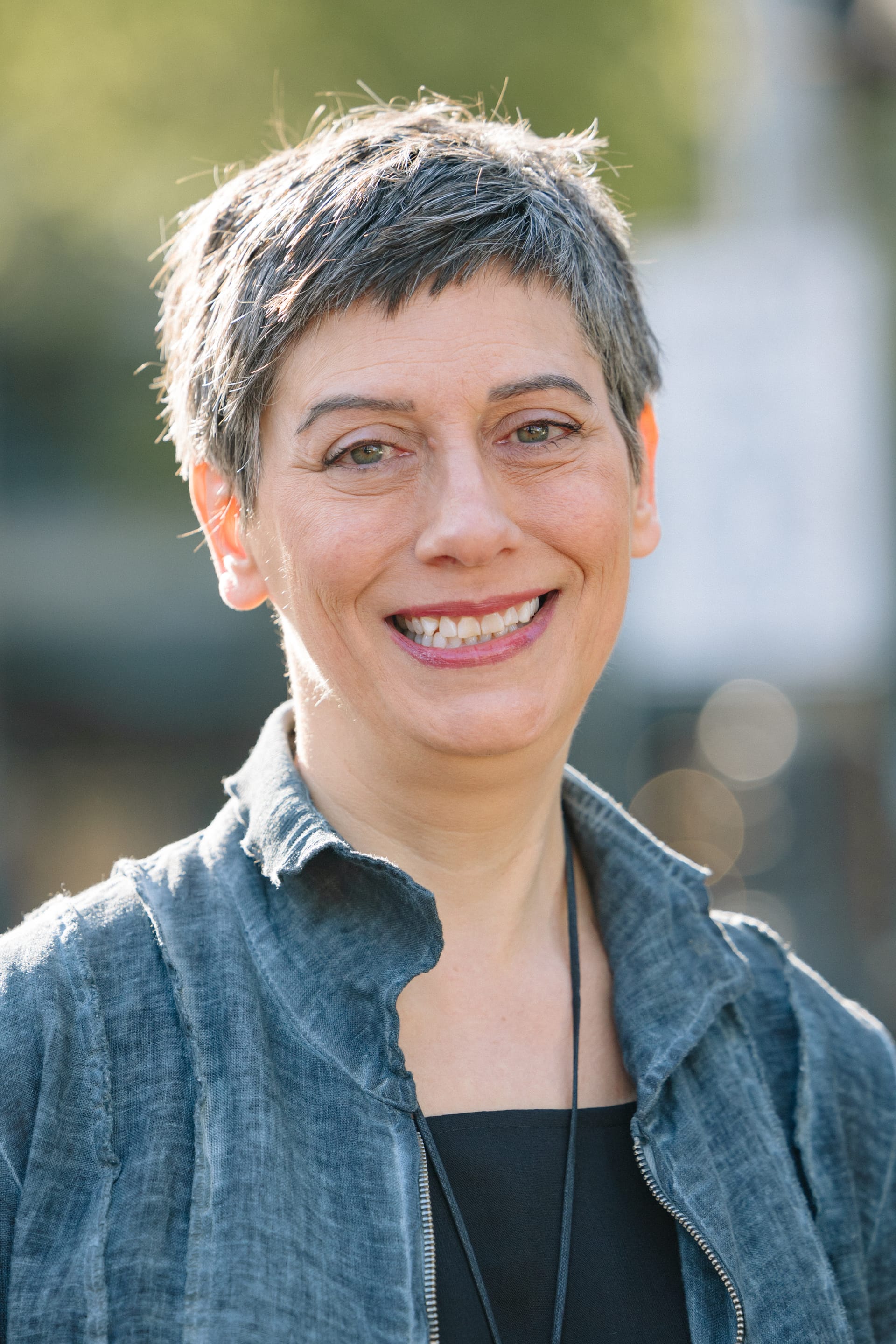 Erica, Simple Life team member, smiling outdoors with short gray hair