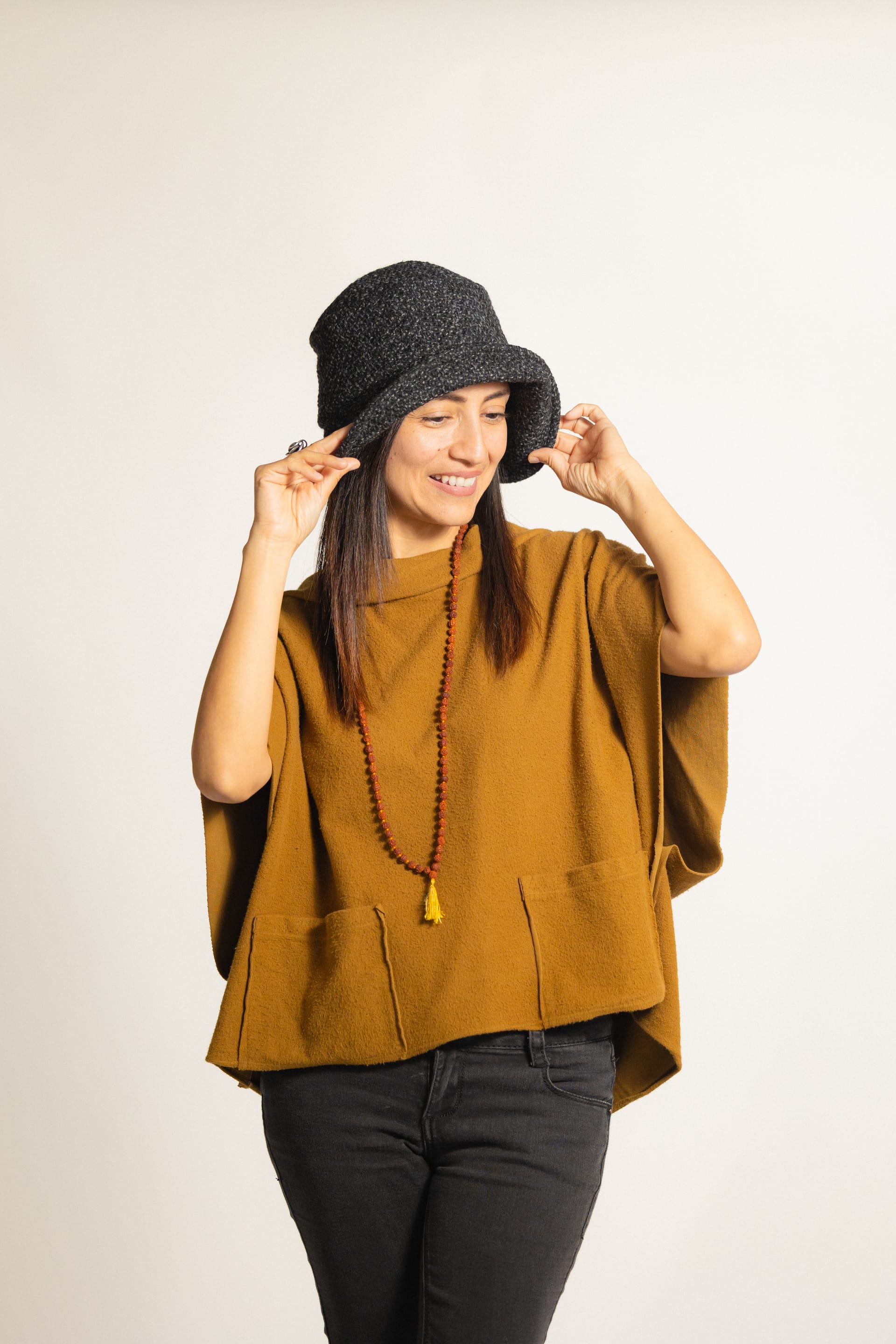 Model wearing knit hat and poncho