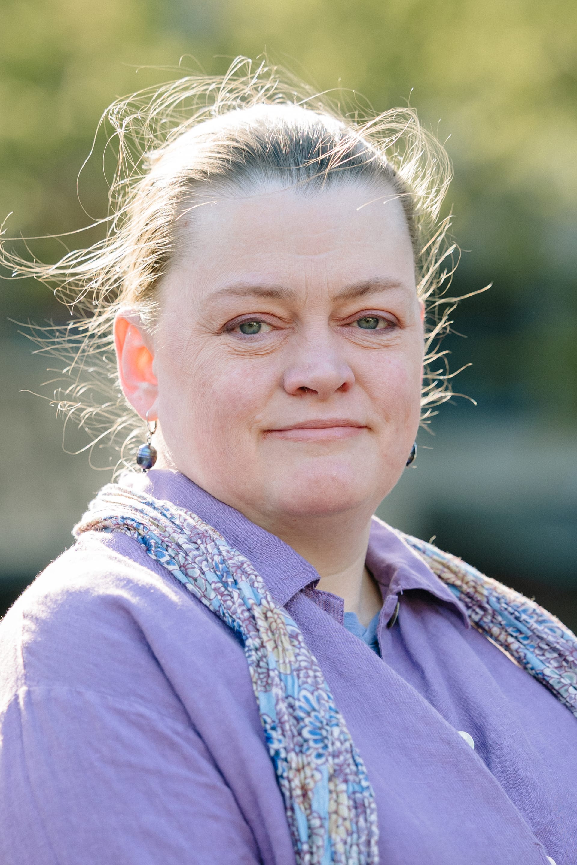 Tammy, Simple Life team member, outdoors in a lavender shirt with a patterned scarf