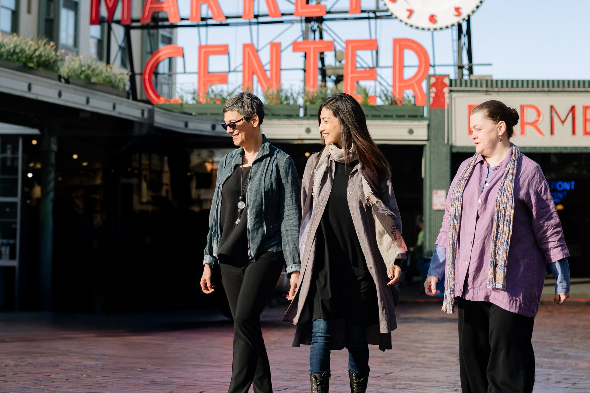 The Simple Life team walking together at Pike Place Market in Seattle, with the Public Market Center sign behind them